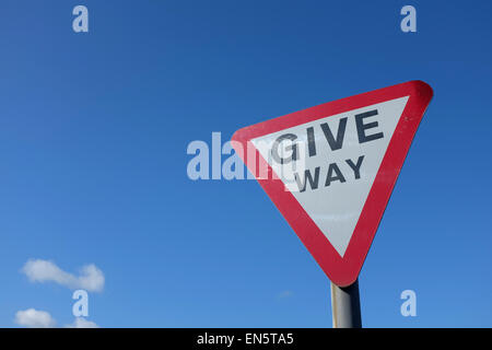 Dare modo cartello stradale contro uno sfondo blu UK Foto Stock