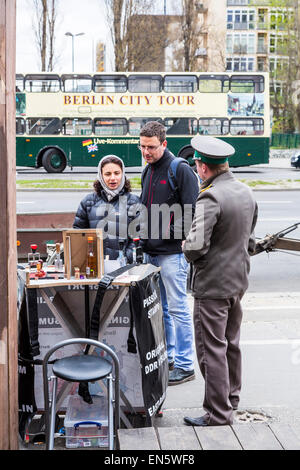 L'uomo nell'ex confine tedesco-orientale le uniformi della polizia vende souvenir ai turisti, Foto Stock
