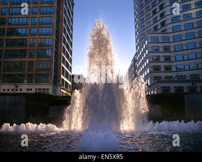 Lussureggianti fontane illuminate dal sole in Cabot Square Canary Wharf London financial district Foto Stock