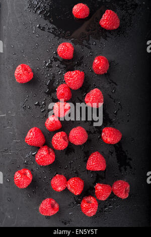 Wet lamponi impostato su nero ardesia Foto Stock