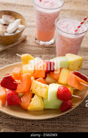 Spiedini di frutta - frutta su spiedini - sul vassoio con fragola frullati Foto Stock