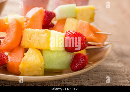 Spiedini di frutta - frutta su spiedini - sul vassoio con fragola frullati Foto Stock