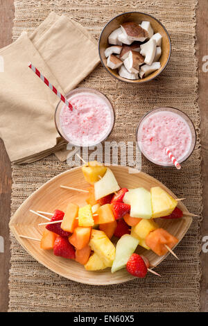 Spiedini di frutta - frutta su spiedini - sul vassoio con fragola frullati Foto Stock