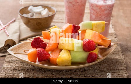 Spiedini di frutta - frutta su spiedini - sul vassoio con fragola frullati Foto Stock