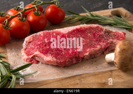 Serie: Striscia di grigliatura Bistecca di lombo in ghisa Padella: Ingredienti inclusi la pila, i funghi, il pomodoro e il rosmarino tagliato Foto Stock