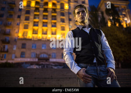 Bel ragazzo in un vestito in piedi sulle scale Foto Stock