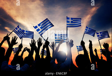 Sagome di persone tiene la bandiera della Grecia Foto Stock