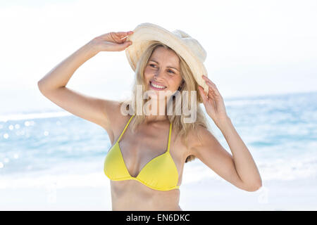 Sorridente bella bionda in bikini indossando cappello di paglia Foto Stock