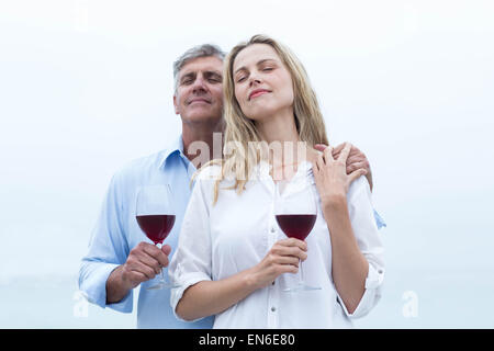 Coppia felice con in mano un bicchiere di vino rosso Foto Stock