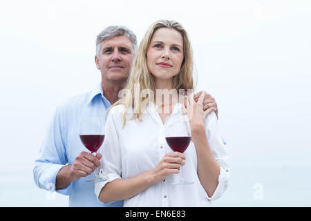 Coppia felice con in mano un bicchiere di vino rosso Foto Stock