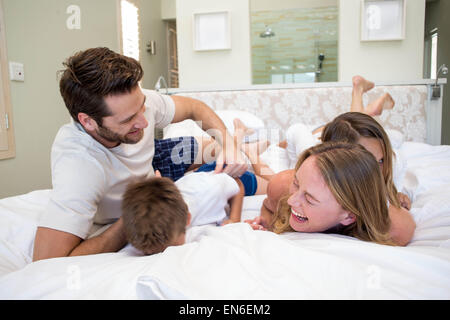 La famiglia felice giocando sul letto Foto Stock