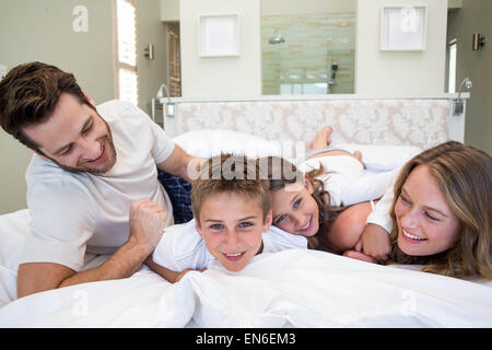 La famiglia felice giocando sul letto Foto Stock