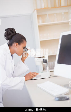 Scienziato guardando attraverso un microscopio Foto Stock
