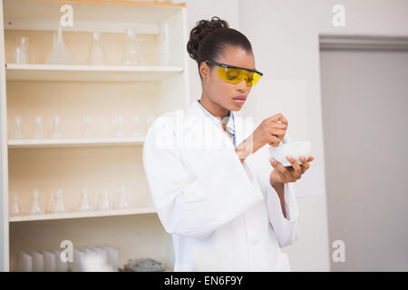 Scienziato concentrato usando il pestello e mortaio Foto Stock