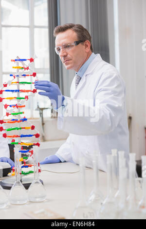 Scienziato analizzando elica di DNA Foto Stock