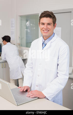 Scienziato sorridente con notebook Foto Stock