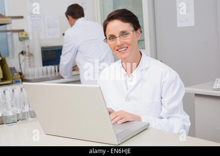 Scienziato sorridente con notebook Foto Stock