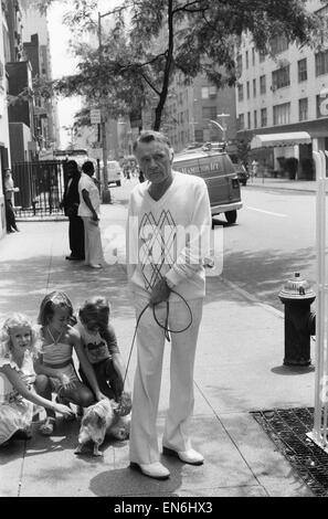 Attore Richard Burton a spasso il suo cane vicino al suo hotel di New York. Egli era stato recentemente protagonista di "Camelot' su Broadway ma era ammalato durante uno dei suoi spettacoli. OPS il suo cane la ricezione di tutte le attenzione da parte di un gruppo di giovani ragazze. Il 22 luglio 1980. Foto Stock