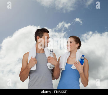 Immagine composita di felice montare giovane coppia con bottiglie di acqua Foto Stock