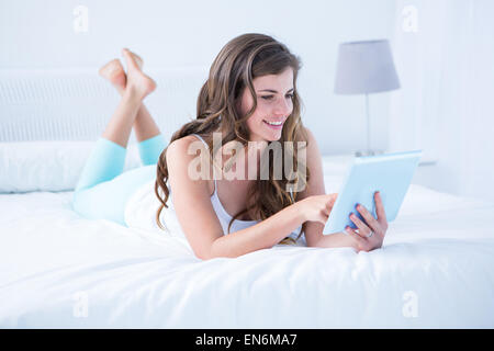 Happy brunette usando il suo computer portatile nel suo letto Foto Stock