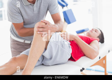 Uomo con massaggio del ginocchio Foto Stock