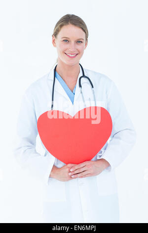 Medico tenendo cuore rosso card Foto Stock