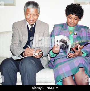 Nelson Mandela leader del Congresso Nazionale Africano (ANC) visto qui rendere note prima di una conferenza stampa al suo arrivo nel Regno Unito, mentre sua moglie Winnie legge una rivista. Il 15 aprile 1990 Foto Stock