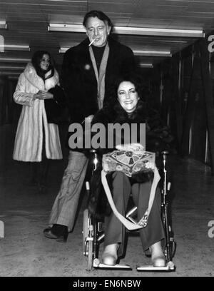 Elizabeth Taylor e Richard Burton raffigurato all aeroporto di Heathrow. Dicembre 1975 Foto Stock