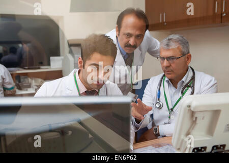 I medici guardando la scansione TC sullo schermo del computer Foto Stock