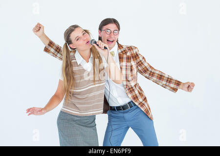 Felice geeky hipsters cantando con microfono Foto Stock