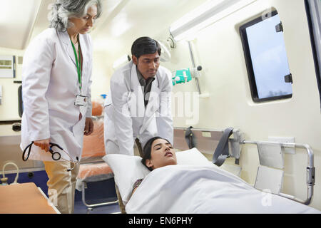 Assistente medico paziente tenendo fuori di ambulanza Foto Stock