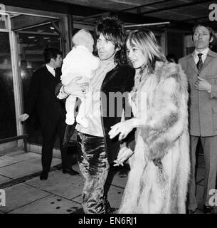 Rolling Stones chitarrista Keith Richards presso l'aeroporto di Heathrow si è riunito di Anita Pallenberg e quattro mese vecchio figlio Marlon, Dicembre 1969 Foto Stock