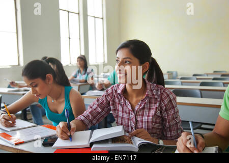 Gli studenti laureati gettando i loro cappelli in aria Foto Stock