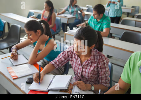 Gli studenti laureati gettando i loro cappelli in aria Foto Stock