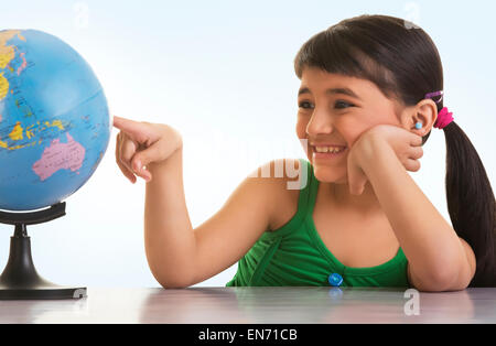 Ragazza guardando un mappamondo Foto Stock