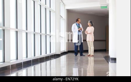 Medico per discutere con la donna in ospedale corridoio Foto Stock