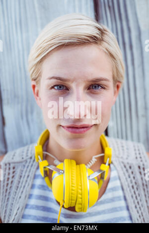 Bella donna bionda che indossa la cuffia di colore giallo Foto Stock