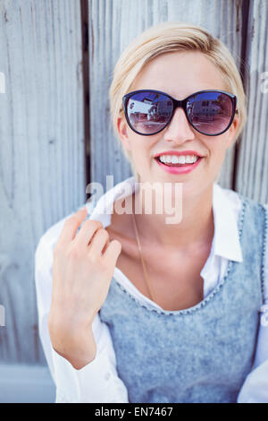 Bella donna bionda indossando occhiali da sole Foto Stock