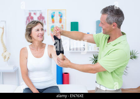 Medico di esaminare i suoi pazienti polso Foto Stock