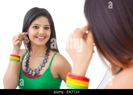 Giovane donna che guarda a se stessa nello specchio Foto Stock