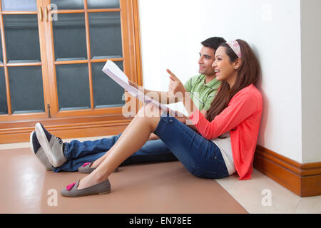 Il giovane e la giovane donna seduta nel bagagliaio di una vettura Foto Stock