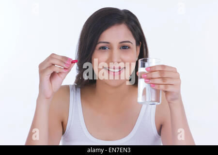 Ritratto di donna con la pillola e bicchiere di acqua Foto Stock