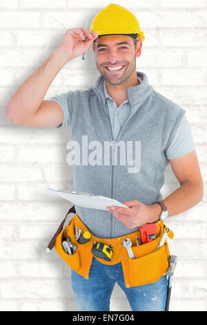 Immagine composita del ritratto di sorridere lavoratore manuale holding negli appunti Foto Stock