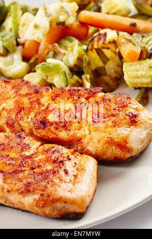 Filetto di salmone alla griglia con verdure fritte su una piastra Foto Stock