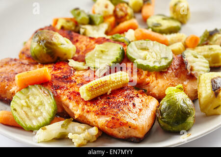 Filetto di salmone alla griglia con verdure fritte su una piastra Foto Stock