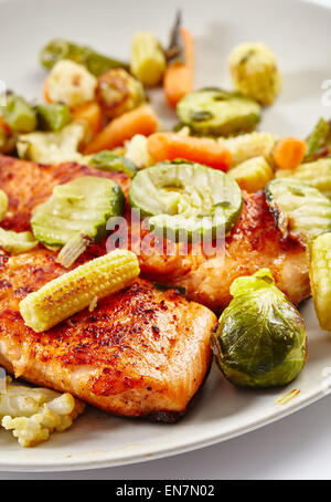 Filetto di salmone alla griglia con verdure fritte su una piastra Foto Stock