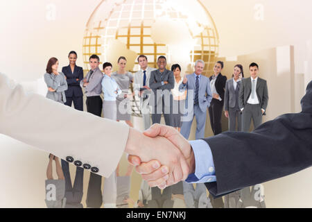 Immagine composita di sorridere la gente di affari si stringono la mano mentre guardando la telecamera Foto Stock