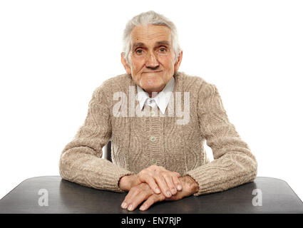 Happy 80 anni vecchio seduto alla scrivania, studio shot Foto Stock