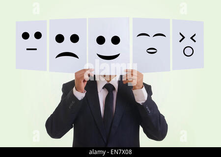 Imprenditore tenendo vari emoticon Foto Stock