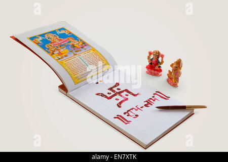 Lakshmi e ganesha idolo con ledger libro e una penna isolata su sfondo bianco Foto Stock